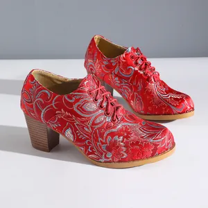 Close-up detail of red retro satin embroidered high heels featuring intricate floral patterns