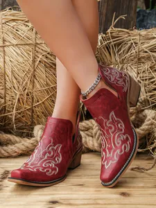 Detailed view of red vintage ankle boots featuring floral embroidery and stylish chunky heels