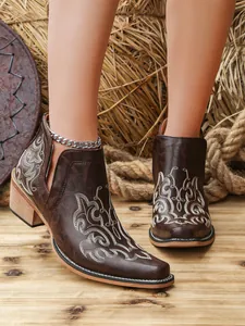Detailed macro view of brown vintage Martin boots with white Western embroidery