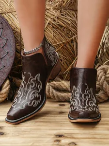 Close-up of vintage brown Western ankle boots with white floral embroidery and v-cut