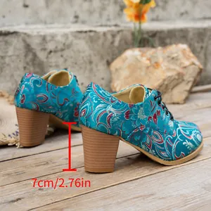 Detailed side view of teal floral embroidered lace-up shoes showing 7cm heel height.