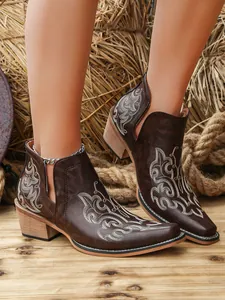 Detailed view of brown vintage cowboy boots featuring floral embroidery and V-cut heels