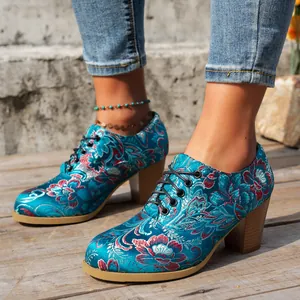 Close-up of vintage teal satin ankle boots with intricate floral embroidery and laces