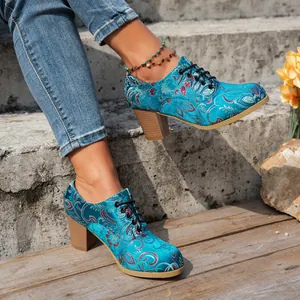 Detail showing the intricate floral embroidery on vintage blue satin lace-up heels.