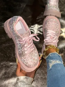 Detail view of pink rhinestone platform sneakers with elegant silk ribbon laces