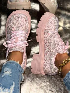 Close-up of pink platform shoes adorned with sparkling rhinestones and satin laces
