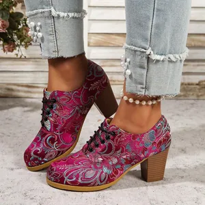 Elegant vintage floral embroidered satin lace-up block heels shown on feet with pearl jeans