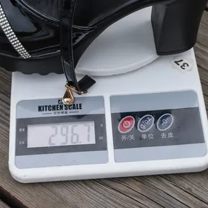 Detail view of black rhinestone platform sandal on a scale showing its lightweight of 296.7g