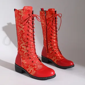 Detailansicht der roten bestickten kniehohen Stiefel mit goldenem Drachenmuster und Blockabsatz