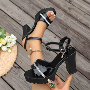 Close-up of black platform sandals with chunky heels and rhinestone strap details.