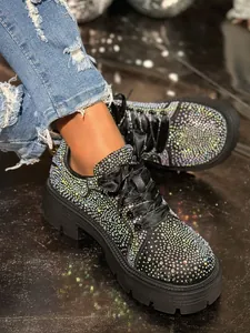 Close-up of sparkling rhinestone sneakers with platform sole and satin laces