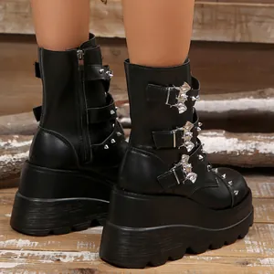 Close-up of black platform boots with bat-shaped buckles and silver studs