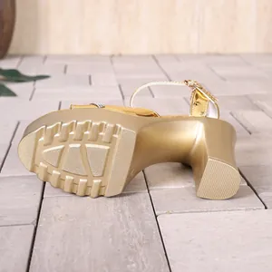 Detail view of gold chunky high heel sandal showing thick lug sole and platform