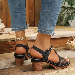 Gros plan de sandales compensées à lanières noires avec talon texture bois