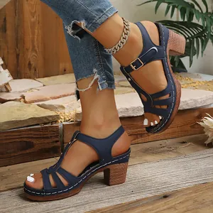 Détail rapproché des sandales bleu marine à talons épais avec bride en T et boucle