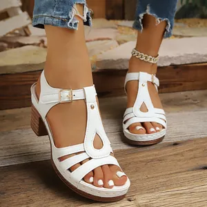 Gros plan de sandales blanches à talons épais avec design en T et boucle de fermeture