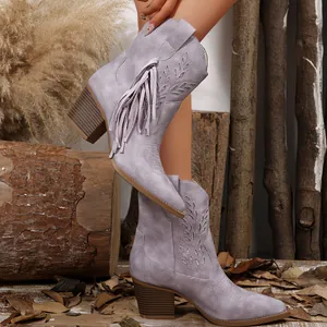 Close-up of lilac western boots featuring intricate embroidery and stylish side tassels