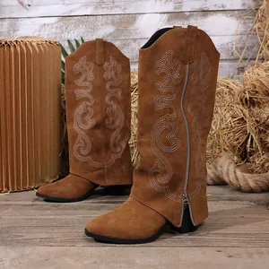 Detailed view of brown suede Western boots with elegant white embroidery and side zipper.