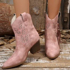 Detailed view of pink embroidered western cowboy boots with fringe and block heel