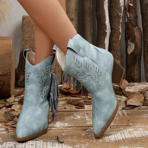 Detailed view of light blue Western cowboy ankle boots with fringe and leaf embroidery