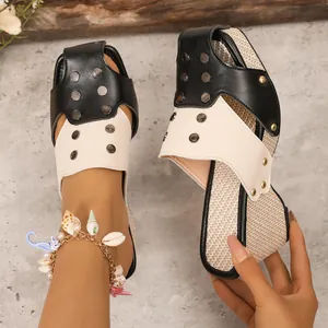 Détail de sandales compensées bicolores pour femmes avec clous et semelle tissée