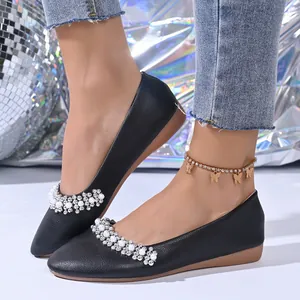 Dettaglio di ballerine nere a punta con eleganti decorazioni di perle e strass