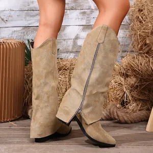 Detail of tan suede-like western boots with intricate embroidery and side zipper.