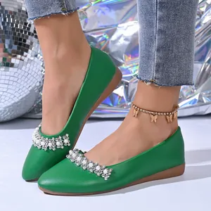 Dettaglio di ballerine verdi a punta con eleganti decorazioni in perle e strass