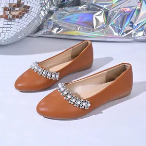 Dettaglio di ballerine marroni a punta con eleganti decorazioni di strass e perle
