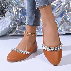 Dettaglio scarpe basse marroni a punta con perle eleganti e strass scintillanti
