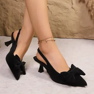 Gros plan d'escarpins noirs élégants à bride arrière avec un grand détail de noeud