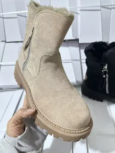 Primo piano di uno stivale da neve in camoscio beige con fodera in pelliccia e cerniera