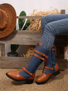 Detail view of denim and leather patchwork knee-high boots with buckle straps