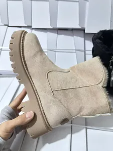 Dettaglio di stivali da neve in camoscio beige con suola spessa e fodera calda
