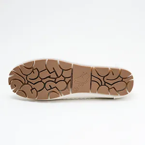 Detailed view of non-slip brown rubber sole of white comfortable loafers