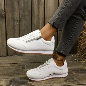 Detail view of comfortable white German army trainer sneakers with a side zipper design.