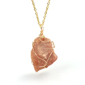Detailed view of wire wrapped natural orange raw crystal stone pendant necklace