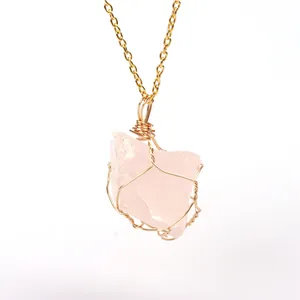 Macro detail of natural rose quartz pendant with gold wire-wrapped design and chain
