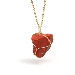Close-up detail of a handmade wire wrapped irregular red raw stone pendant necklace