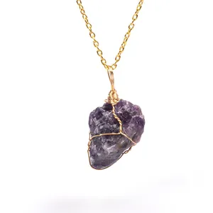 Detailed view of hand-wrapped natural raw amethyst stone pendant on gold chain