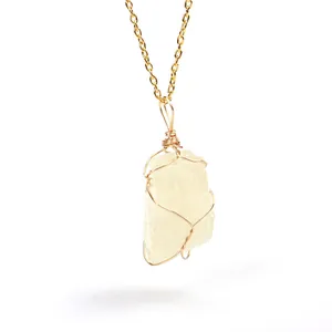 Detailed close-up of natural raw citrine crystal pendant with handmade gold wire wrap detail