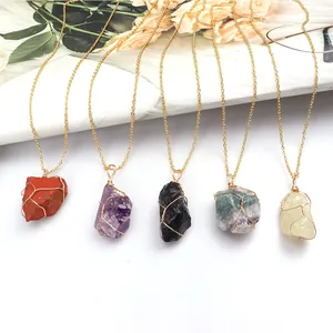Detailed view of five multi-colored wire wrapped natural raw stone crystal pendants