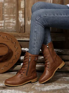 Detailansicht brauner mittelhoher Lederstiefel mit seitlichem Reißverschluss und Schnürung