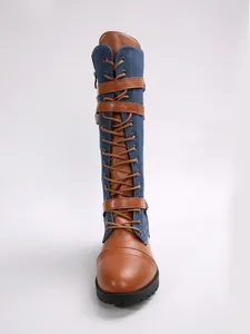 Frontal view showing details of denim and faux leather patchwork knee-high boots with laces