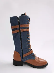 Detail view of denim and leather patchwork knee-high boots with buckles and laces