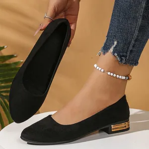 Side profile of black suede pointed-toe flats featuring a gold block heel detail