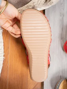 Close-up of anti-slip rubber sole on red wedge sandals with engraved size 37 mark