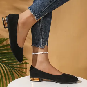 Close-up of black suede pointed-toe flats with gold-accented low square heels.