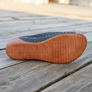 Close-up view of the non-slip wood-grain textured sole of a women's wedge sandal