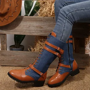 Close-up of denim and leather patchwork knight boots with buckle straps and laces design